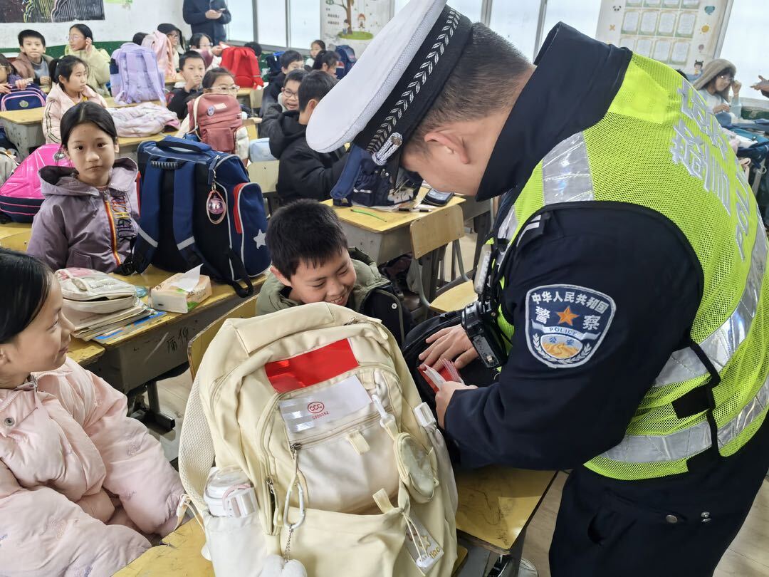 暖心！汨罗白水交警为千余学生书包粘贴反光条