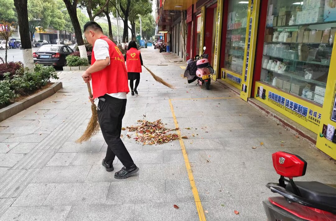 香樟落叶"红"了罗城 归义街道开展落叶志愿清扫活动