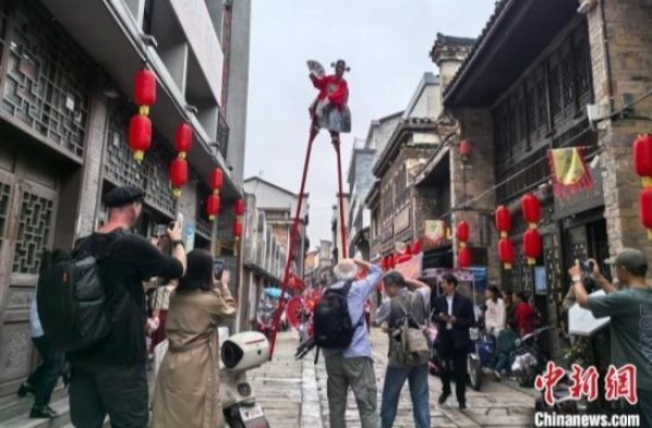 【中国新闻网】大美江湖 天下岳阳 | 湖南“高跷王子”踩5米高跷逛街 外国摄影师直呼“太震撼”