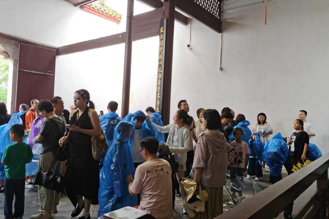 端午骤雨中的汨罗：龙舟赛虽取消，屈子祠雨衣相赠暖人心